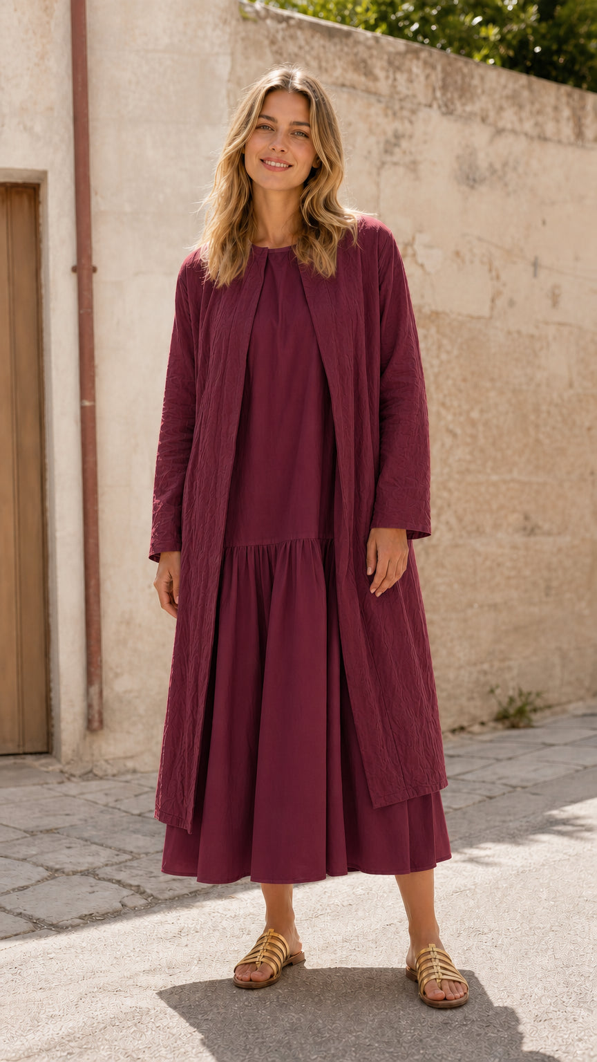 Woman wearing burgundy open front longline duster coat over matching dress