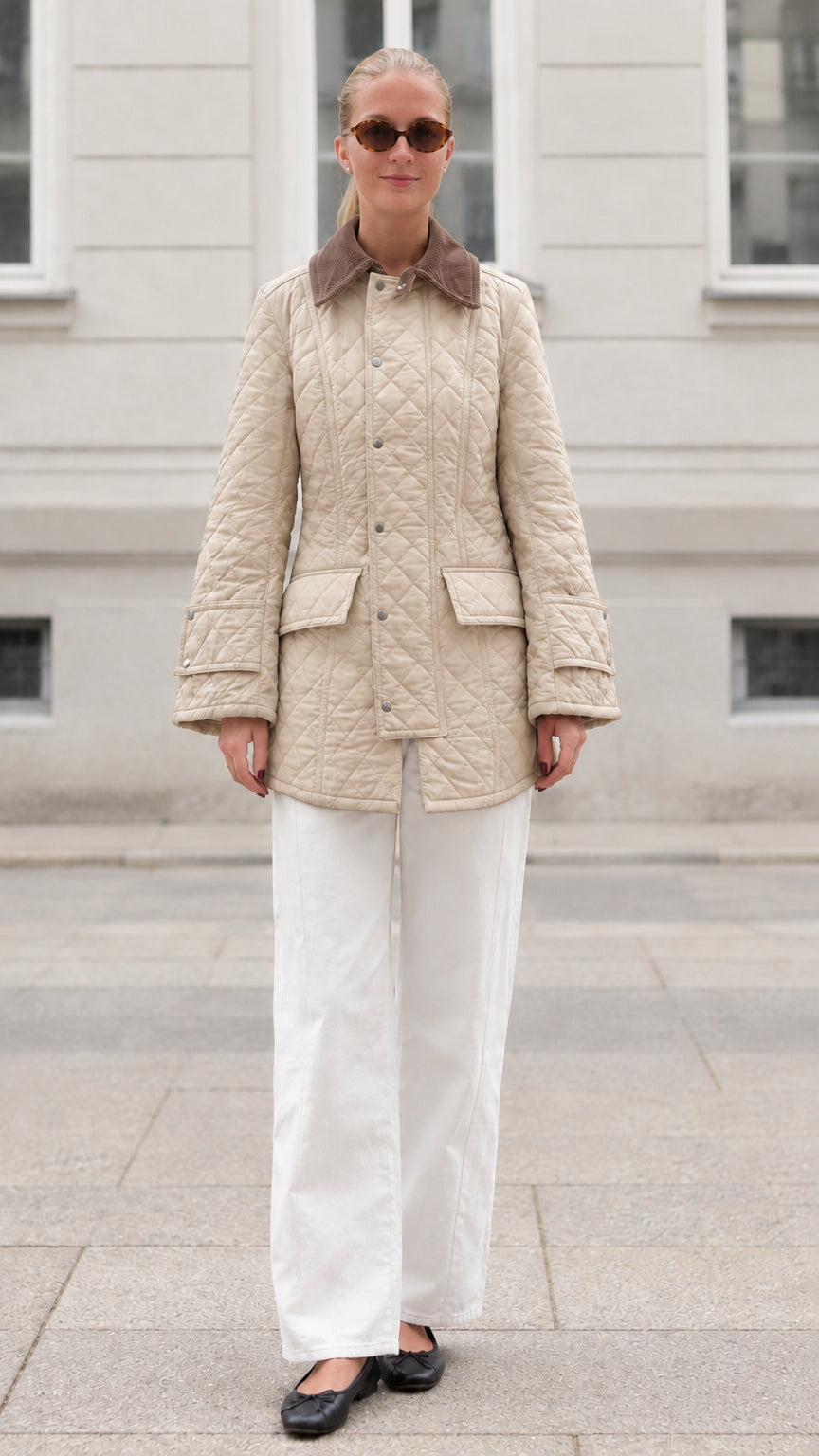 Front full-length view of woman wearing beige diamond quilted barn jacket