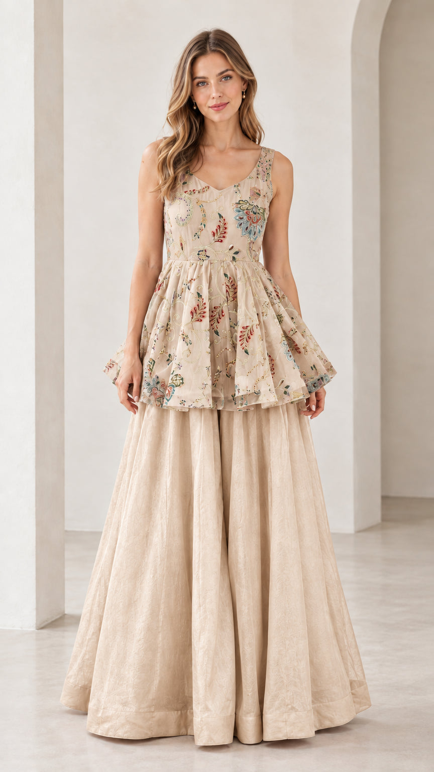 Front view of model wearing champagne beige embroidered peplum top and pants set