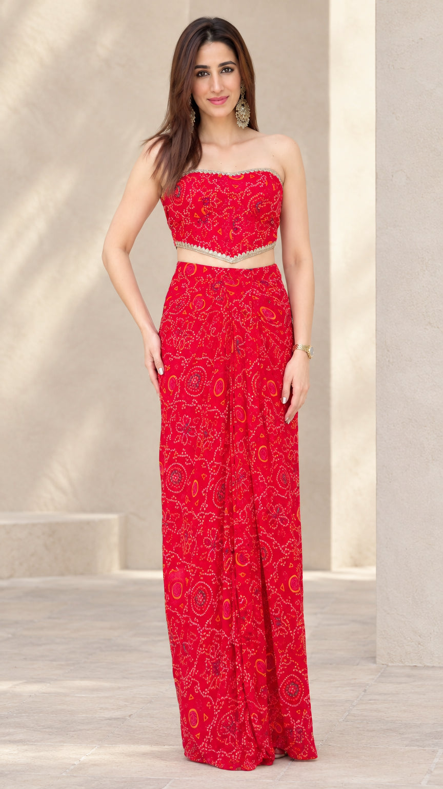 Front full view of woman wearing Red strapless crop top and draped maxi skirt set