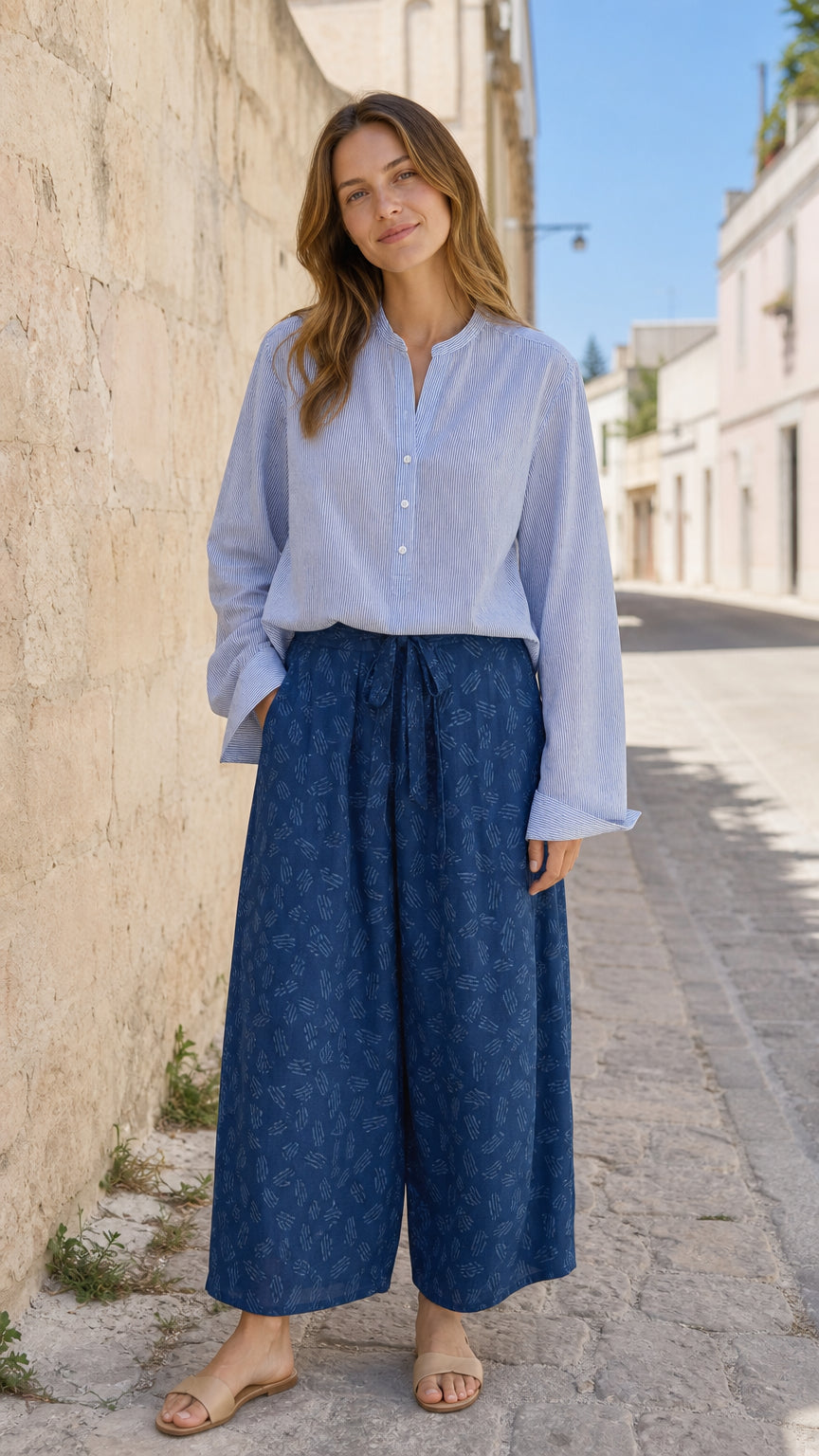 Front view of woman wearing blue long sleeve blouse and patterned wide leg pants