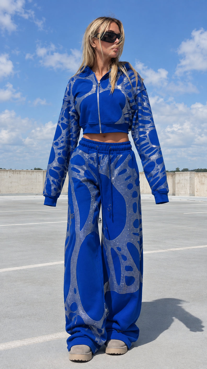 Model wearing royal blue rhinestone cropped hoodie and wide leg sweatpants tracksuit set front view