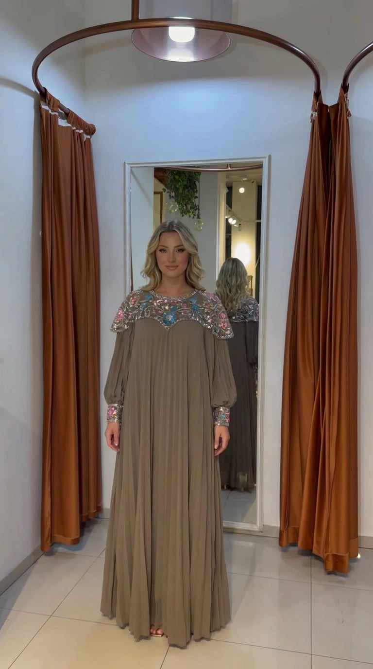 Front view of woman wearing mocha pleated maxi dress with crystal-embroidered yoke