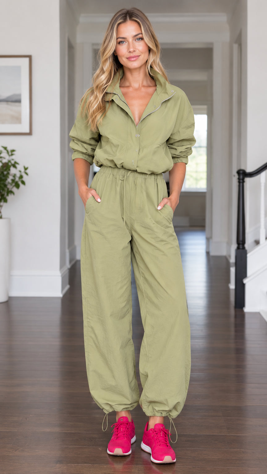 Front view of model wearing olive green utility parachute jumpsuit with drawstring waist