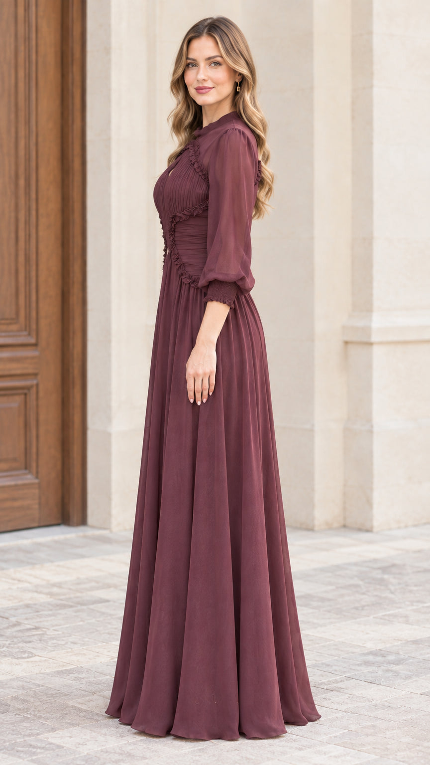 Side profile view of woman modeling long burgundy chiffon evening dress