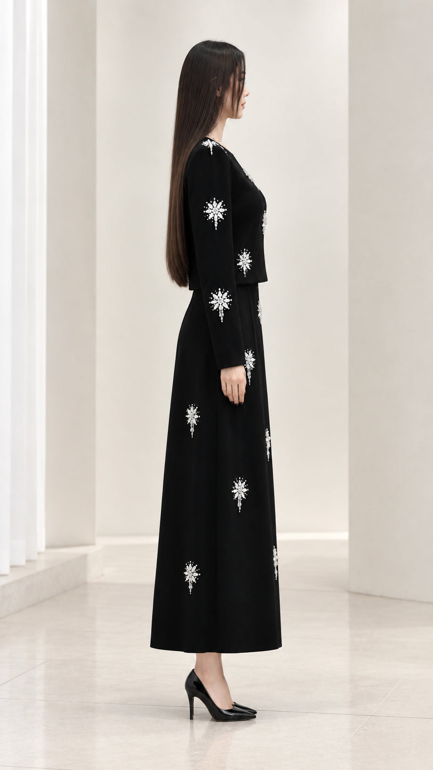 Side profile view of black embellished two-piece skirt set