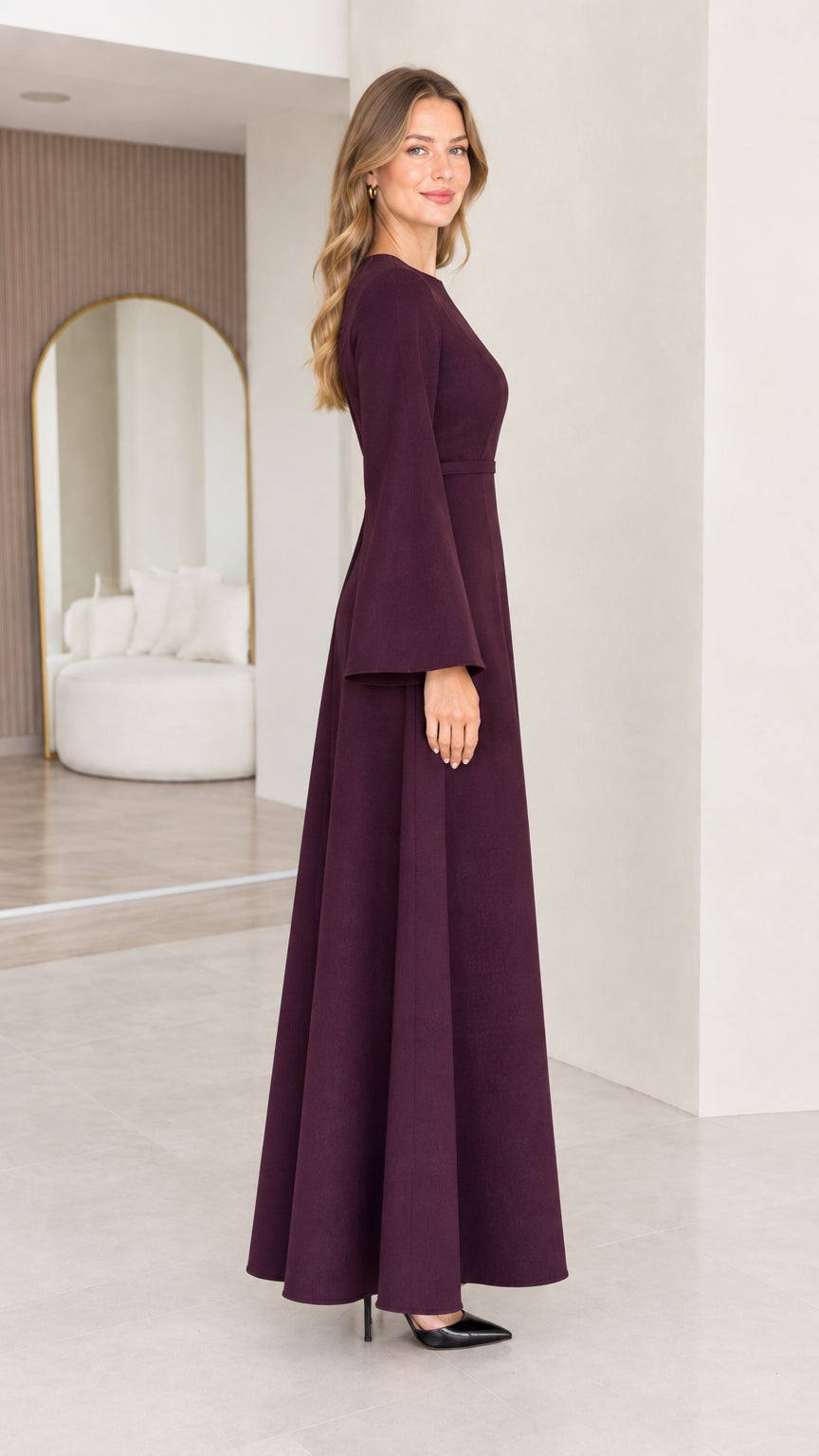 Side view of the burgundy long sleeve maxi dress showing its flowing A-line skirt