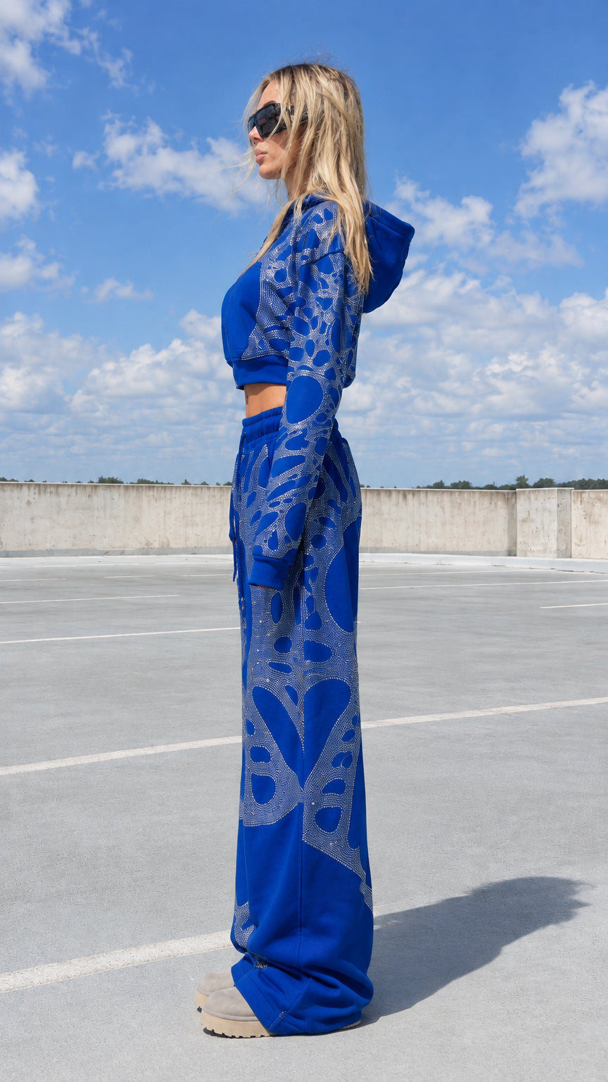 Side view of model in royal blue rhinestone graphic 2-piece sweat suit