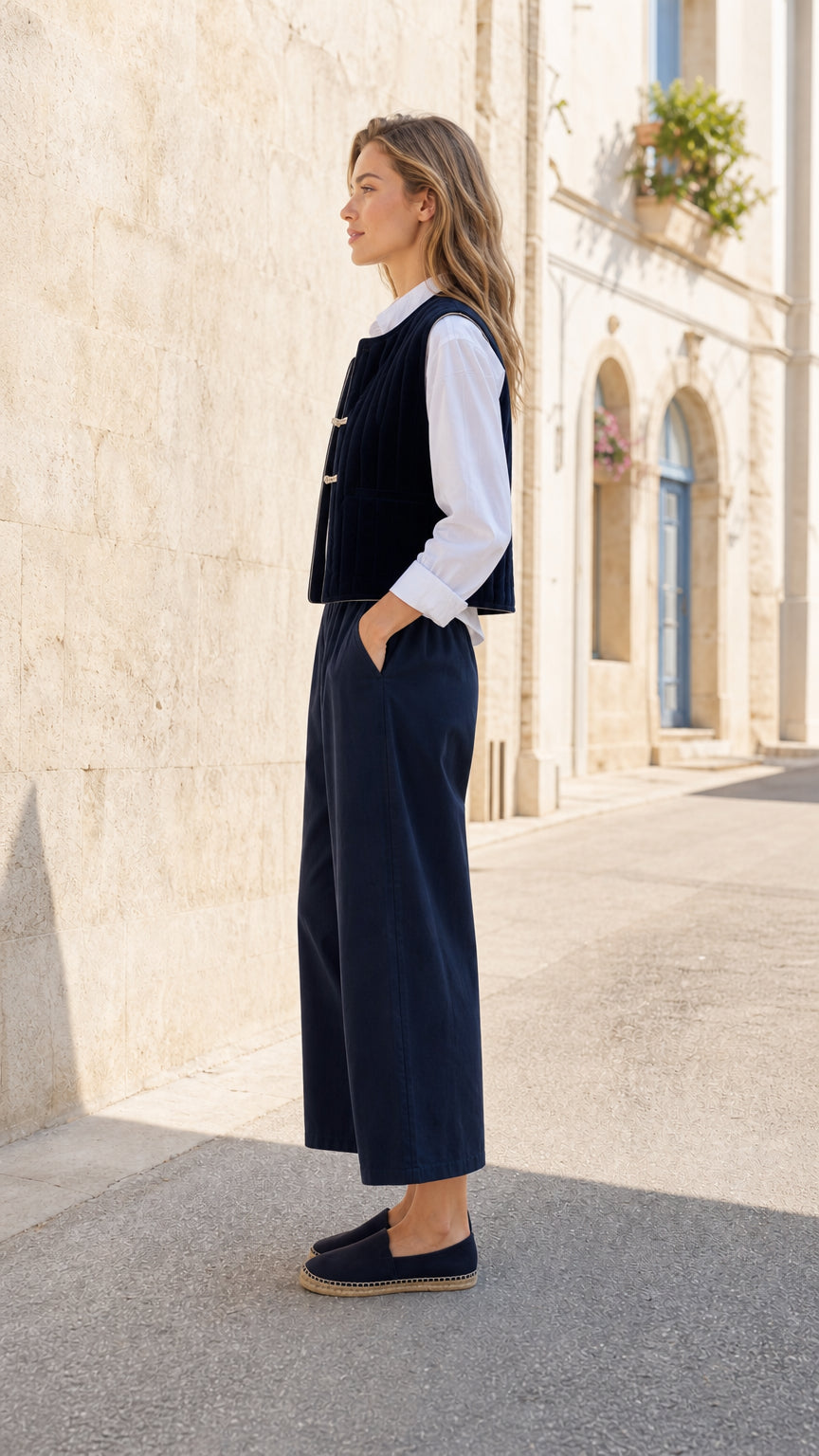 Woman wearing Navy quilted vest and wide-leg pants co-ord set, side profile view