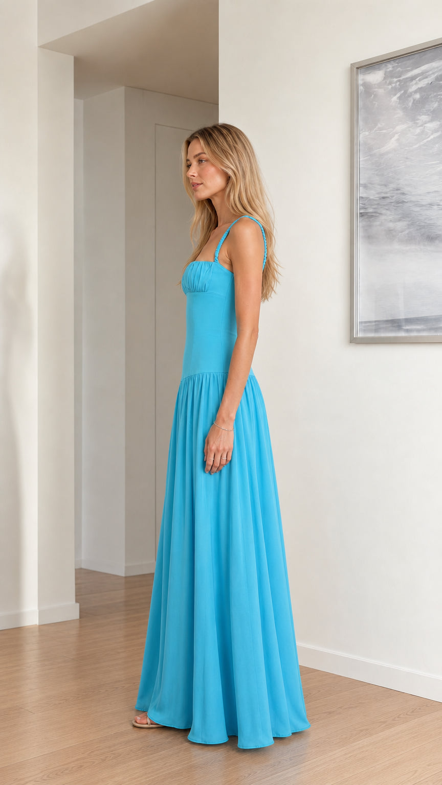 Side profile of model wearing sky blue sleeveless drop waist maxi dress