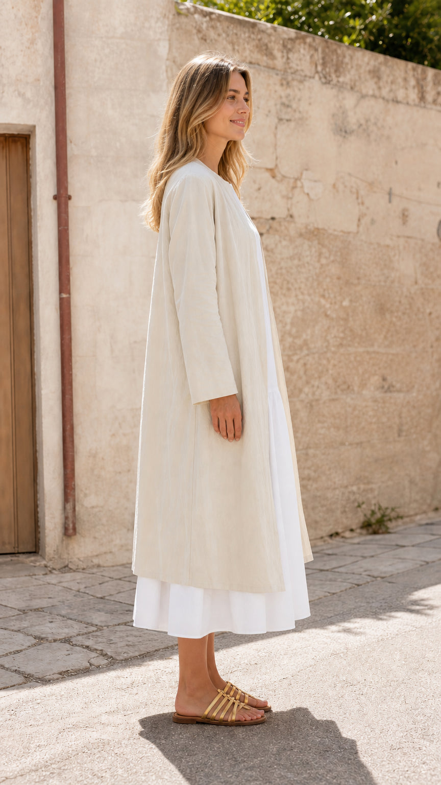 Woman wearing beige duster coat, side profile view