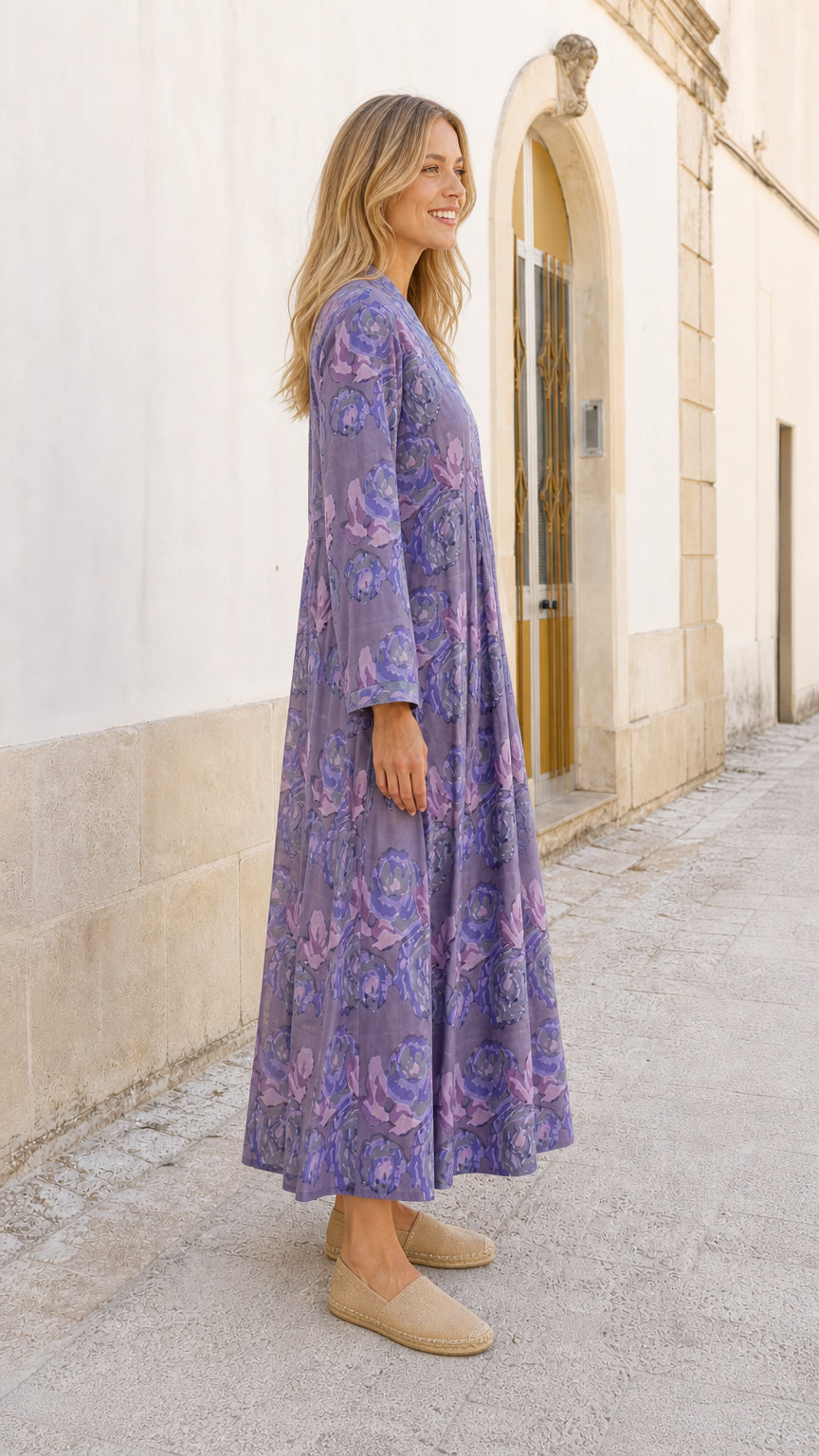 Side profile view of model in purple floral maxi dress