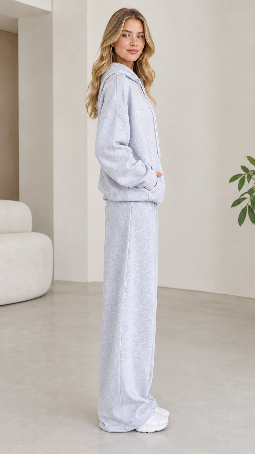 Side profile of model wearing light grey hoodie and wide leg sweatpants set