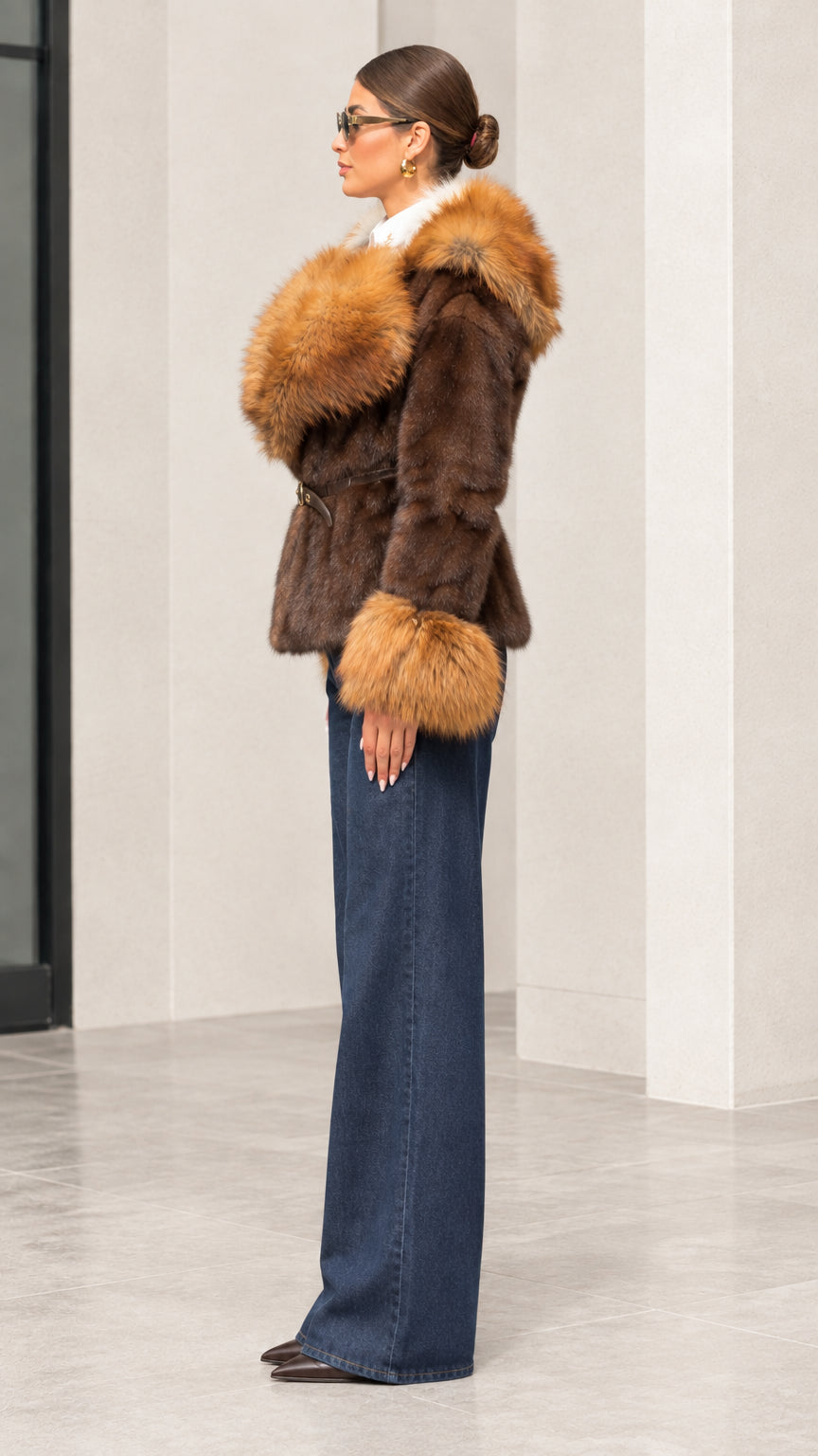 Side profile view of woman modeling brown faux fur trim hooded jacket paired with wide-leg jeans