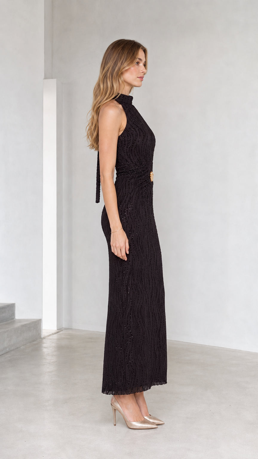 Side profile of model wearing black high neck column maxi dress