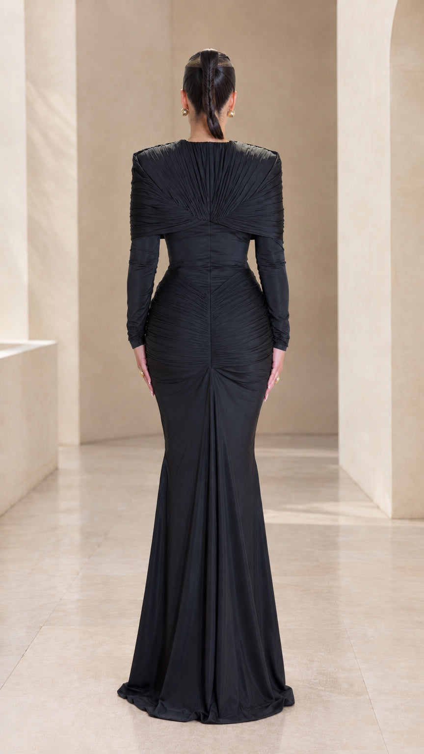 Back view of black structured cape shoulder long sleeve floor-length dress