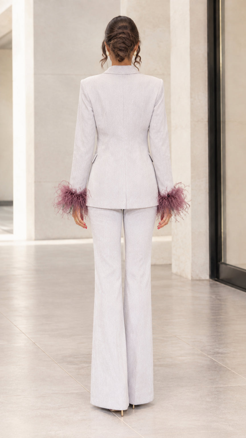 Back view of woman showing tailored silhouette of light grey blazer and flare pants