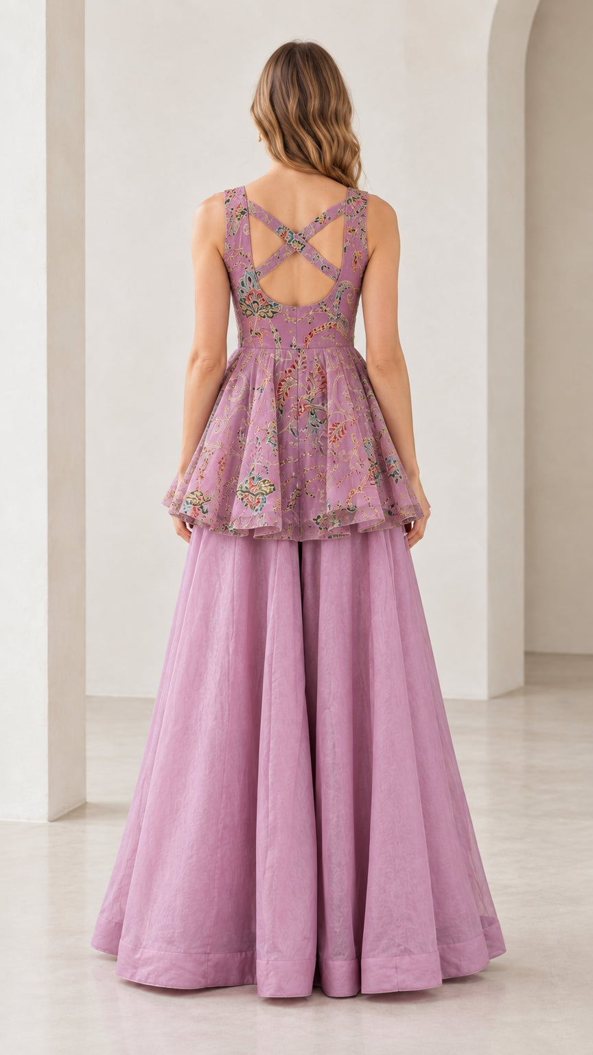 Back view of model showing strappy cross-back cutout detail on lilac peplum set
