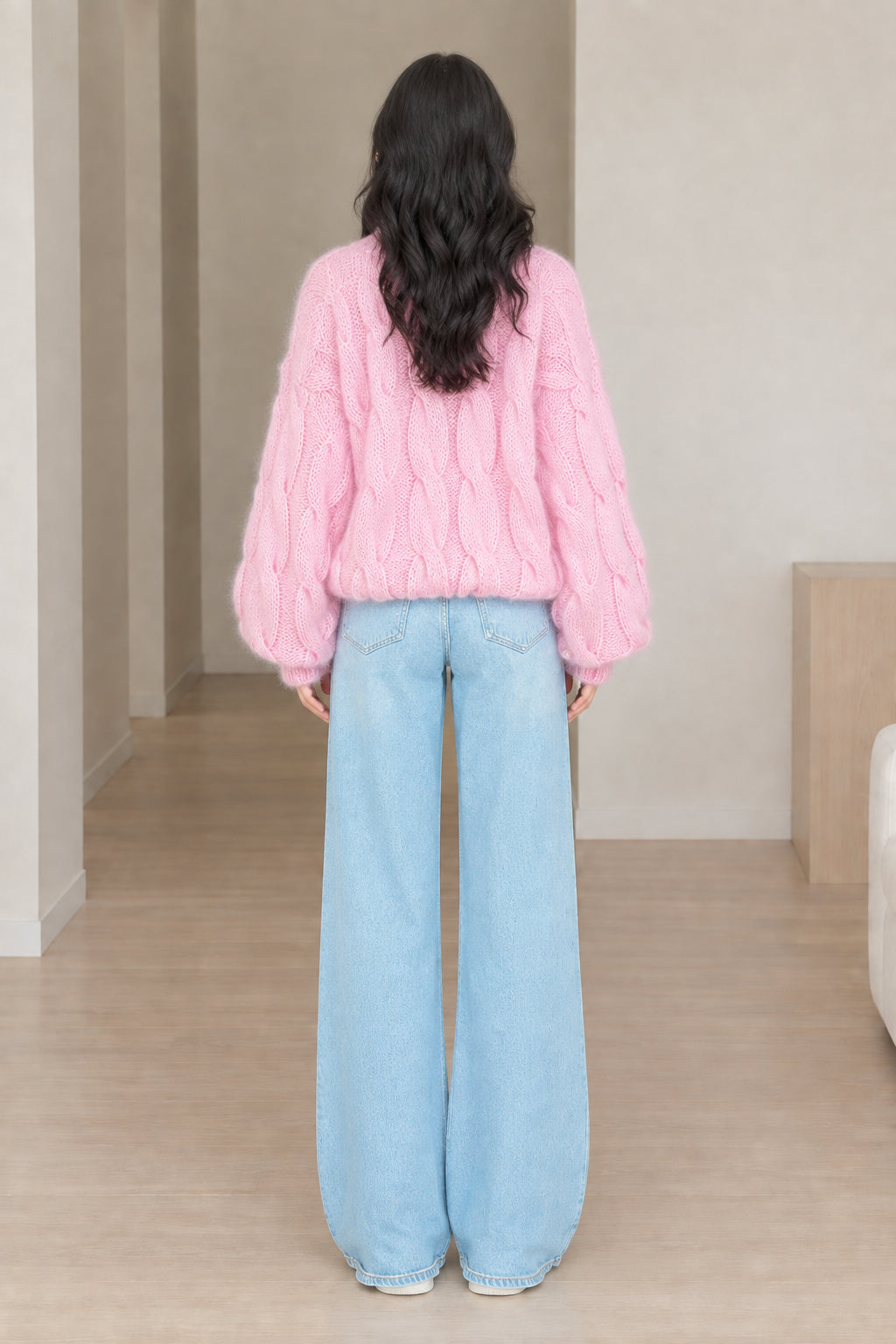Back view of model wearing pink chunky cable knit turtleneck sweater