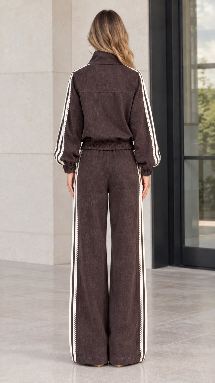 Back view of woman wearing brown corduroy track jacket and wide-leg trousers