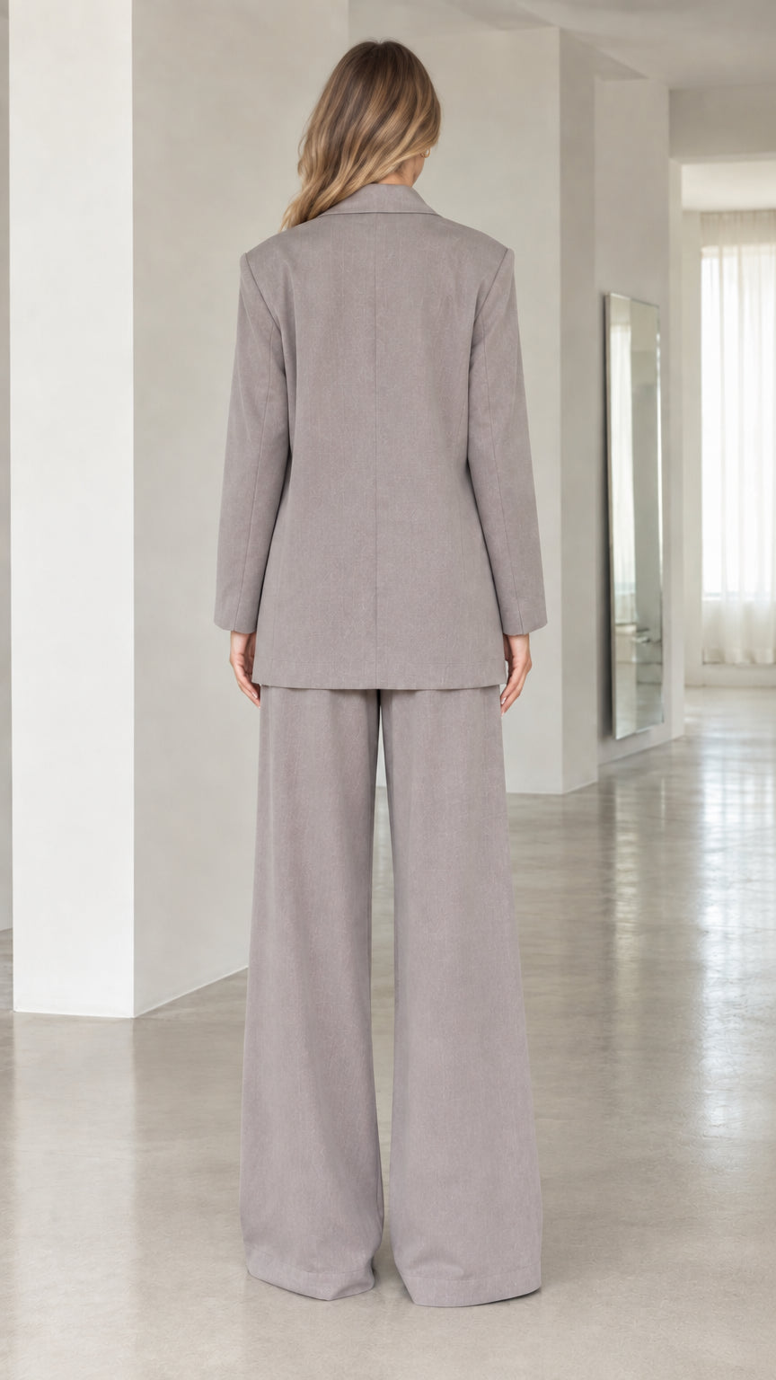 Back view of women's taupe grey tailored suit jacket and wide-leg pants