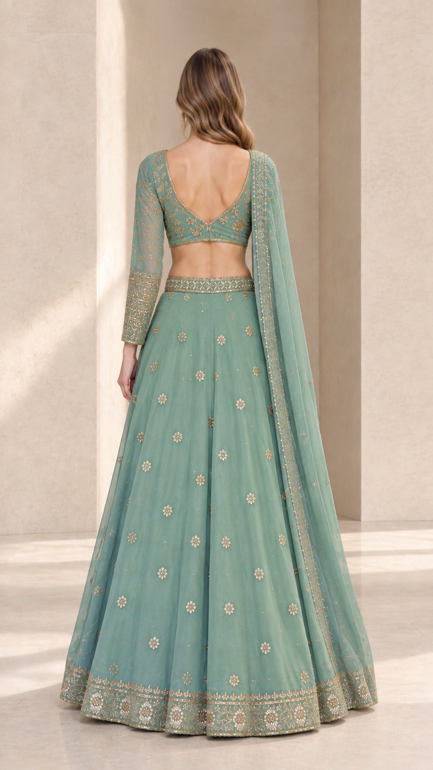 Back view of woman wearing sage green lehenga choli showing V-back design