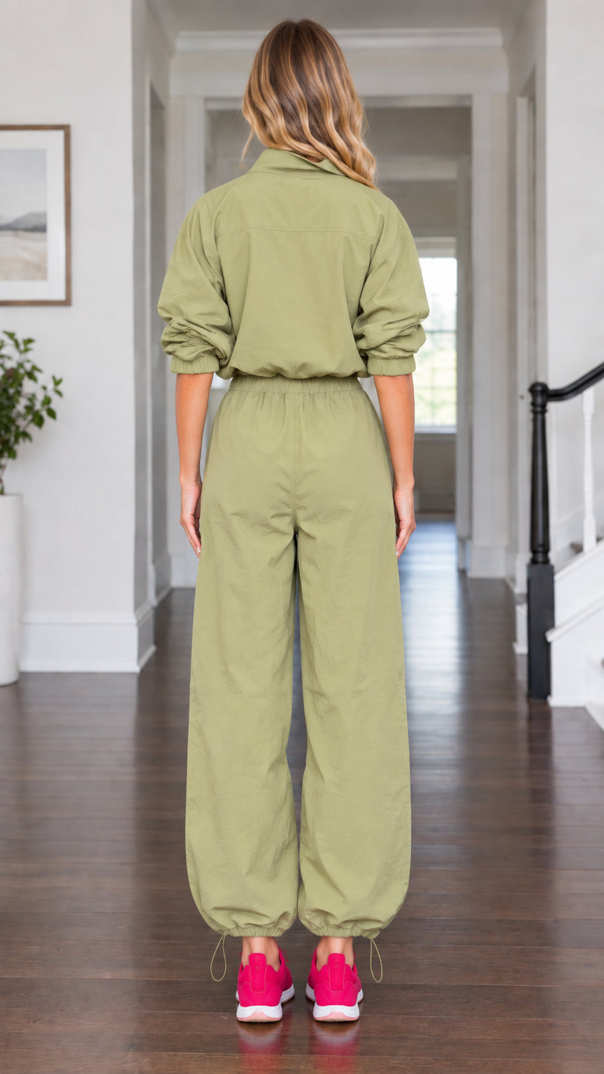 Back view of model wearing olive green long sleeve utility jumpsuit