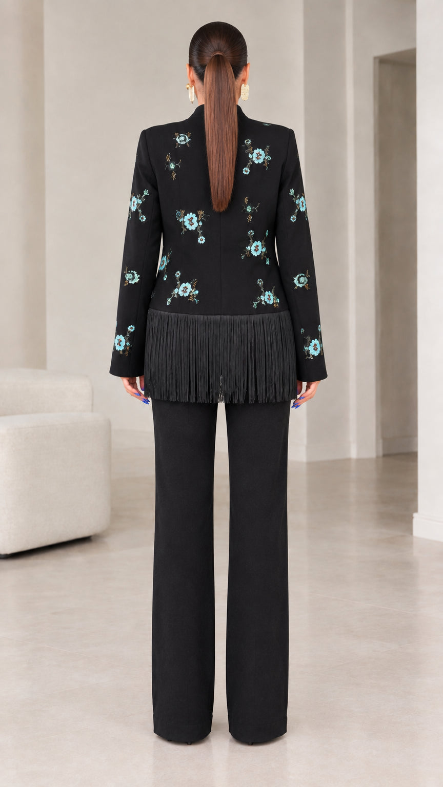 Back view of black stand-collar jacket showing floral embroidery and tassel fringe hem