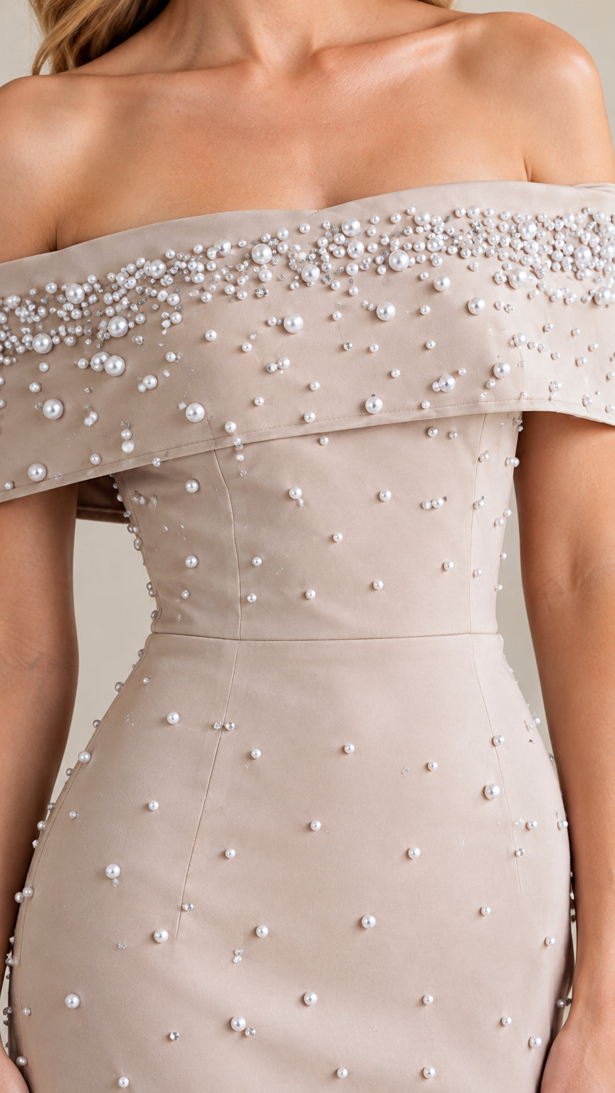 Close-up detail of pearl embellishments on foldover off-the-shoulder neckline and bodice