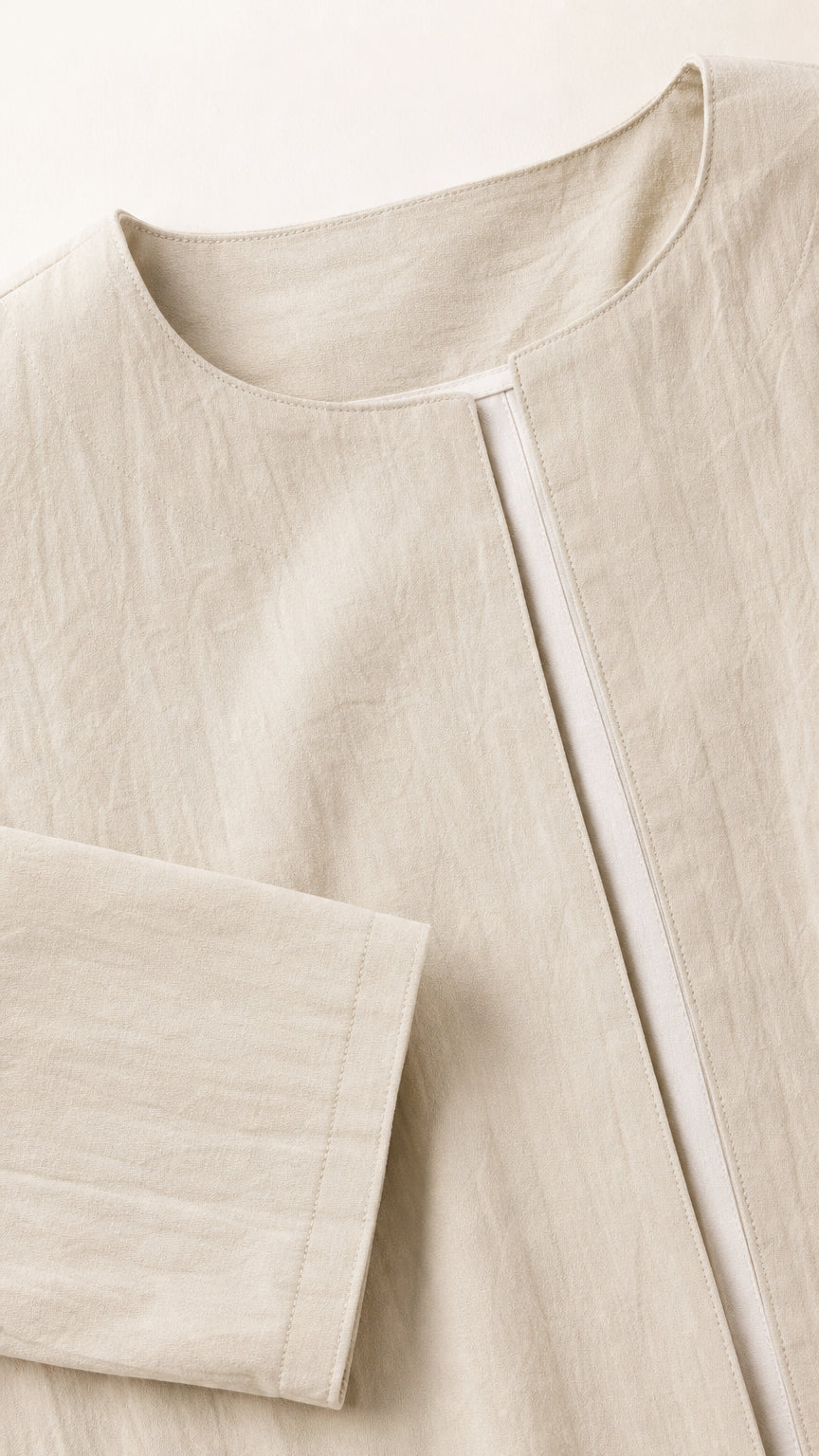 Close-up detail of beige duster coat collar and sleeve cuff