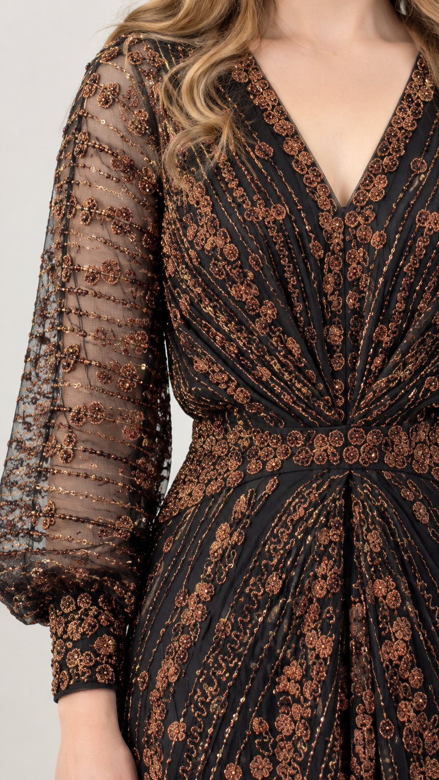 Close-up detail of sheer lantern sleeve with intricate bronze sequin pattern and button cuff