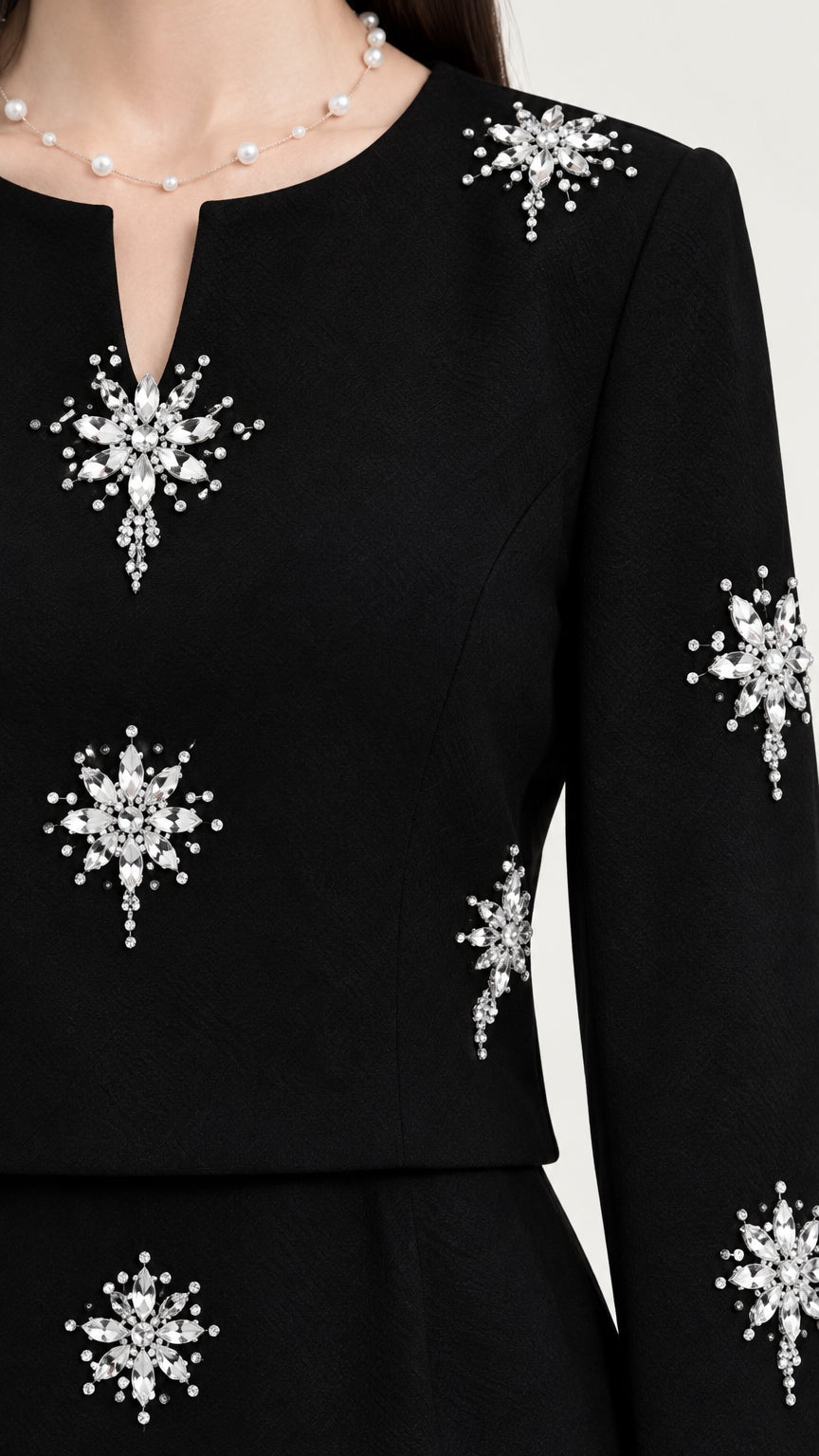 Close-up of sparkling rhinestone starburst embellishments and notched neckline