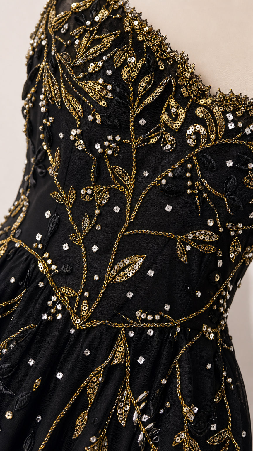 Close-up detail of botanical sequin and bead embroidery on black mesh fabric