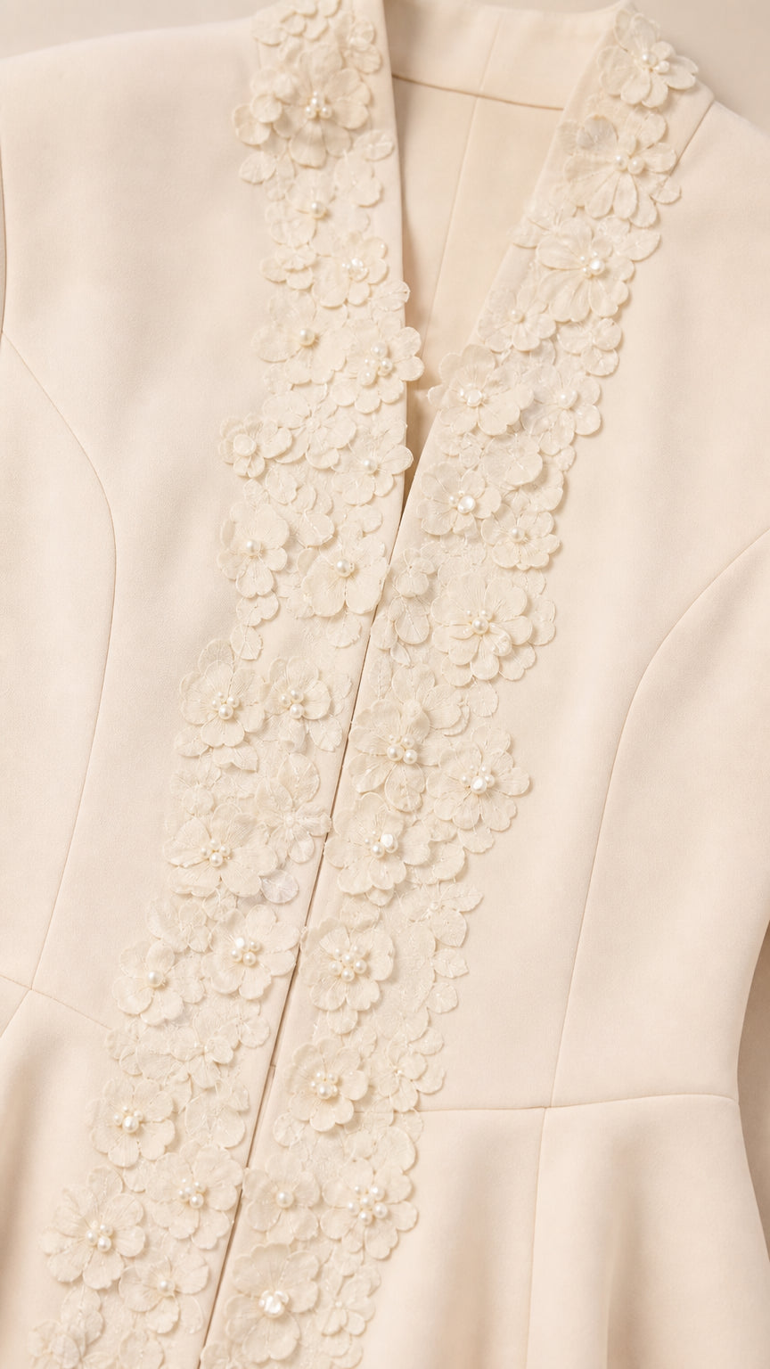Close-up of ivory jacket neckline featuring 3D floral appliqué and pearl bead details