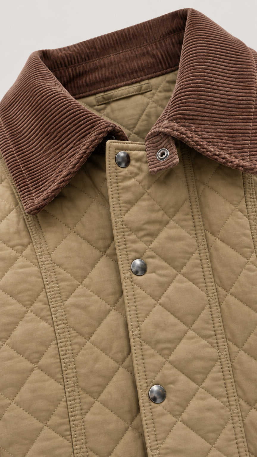Close-up detail of brown corduroy collar, diamond quilting, and snap buttons
