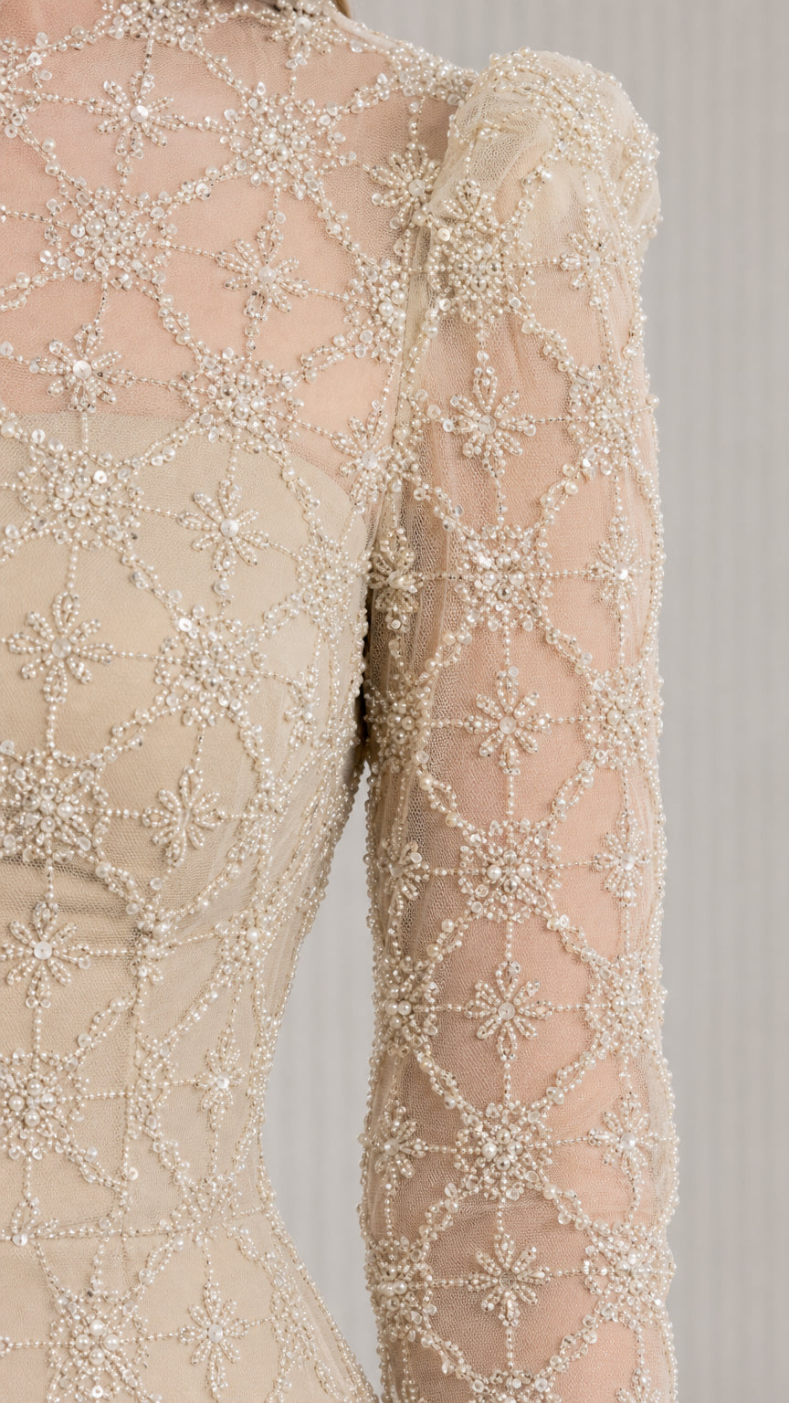 Close-up detail of champagne beaded mesh overlay and illusion neckline