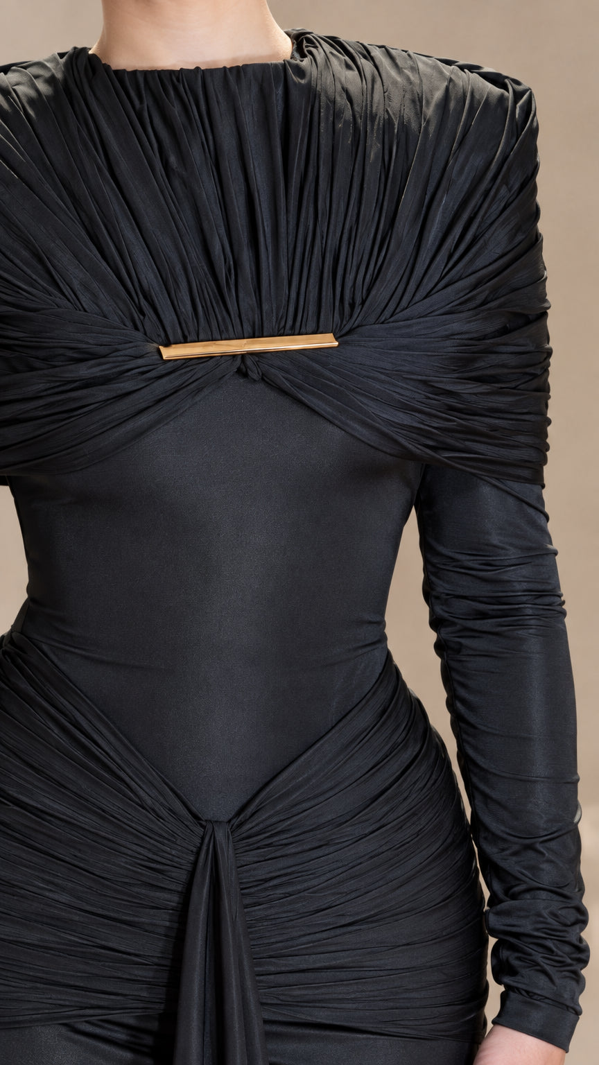 Close-up detail of black pleated cape bodice with central gold bar hardware