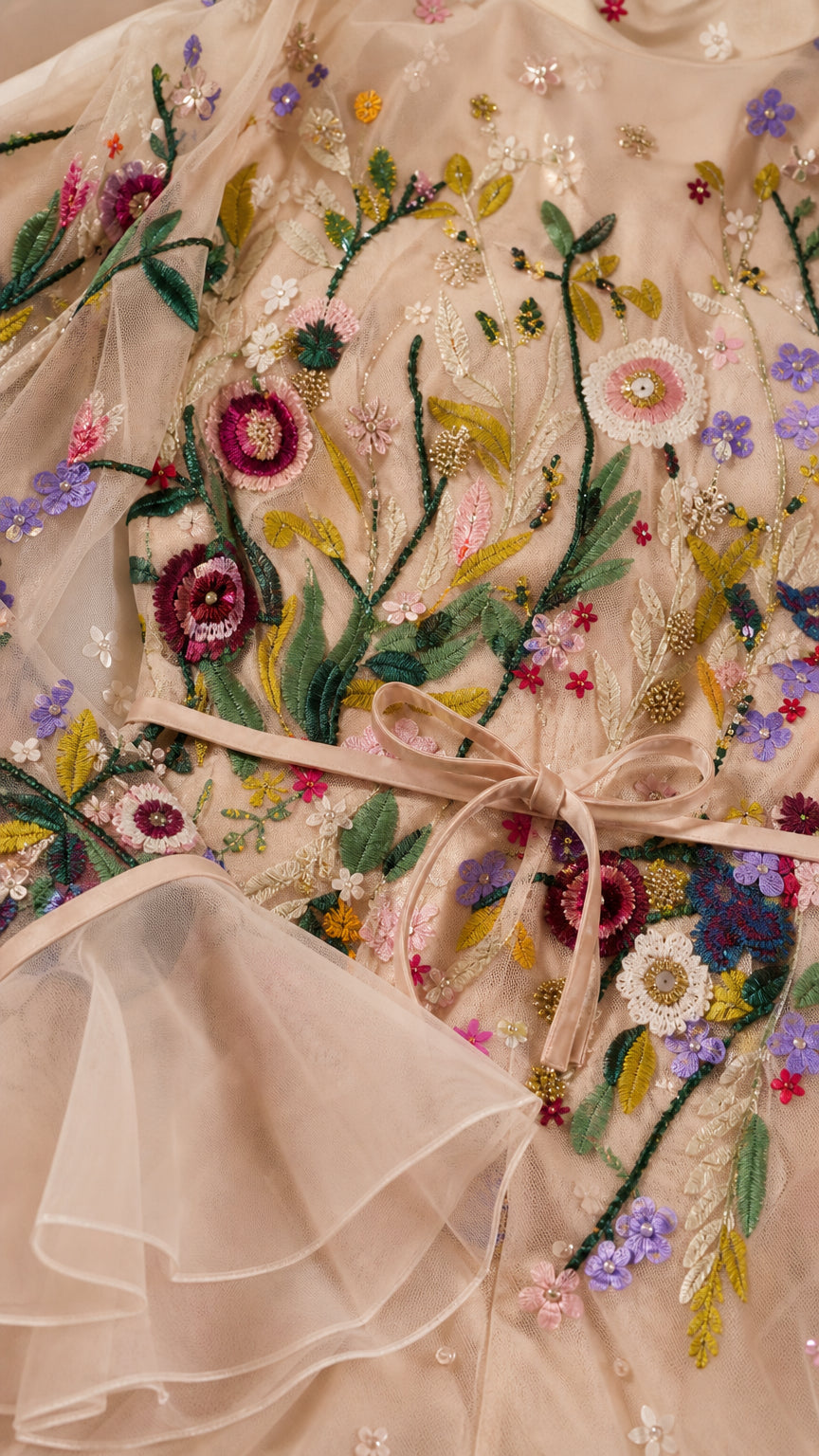 Close-up detail of botanical floral embroidery and ruffled cuff on blush tulle dress