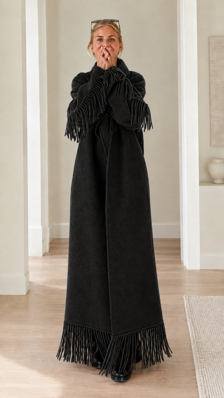 Full-length view of woman wearing black fringe trimmed maxi overcoat