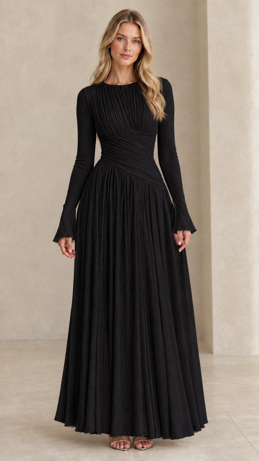 Model wearing black long sleeve pleated maxi evening dress