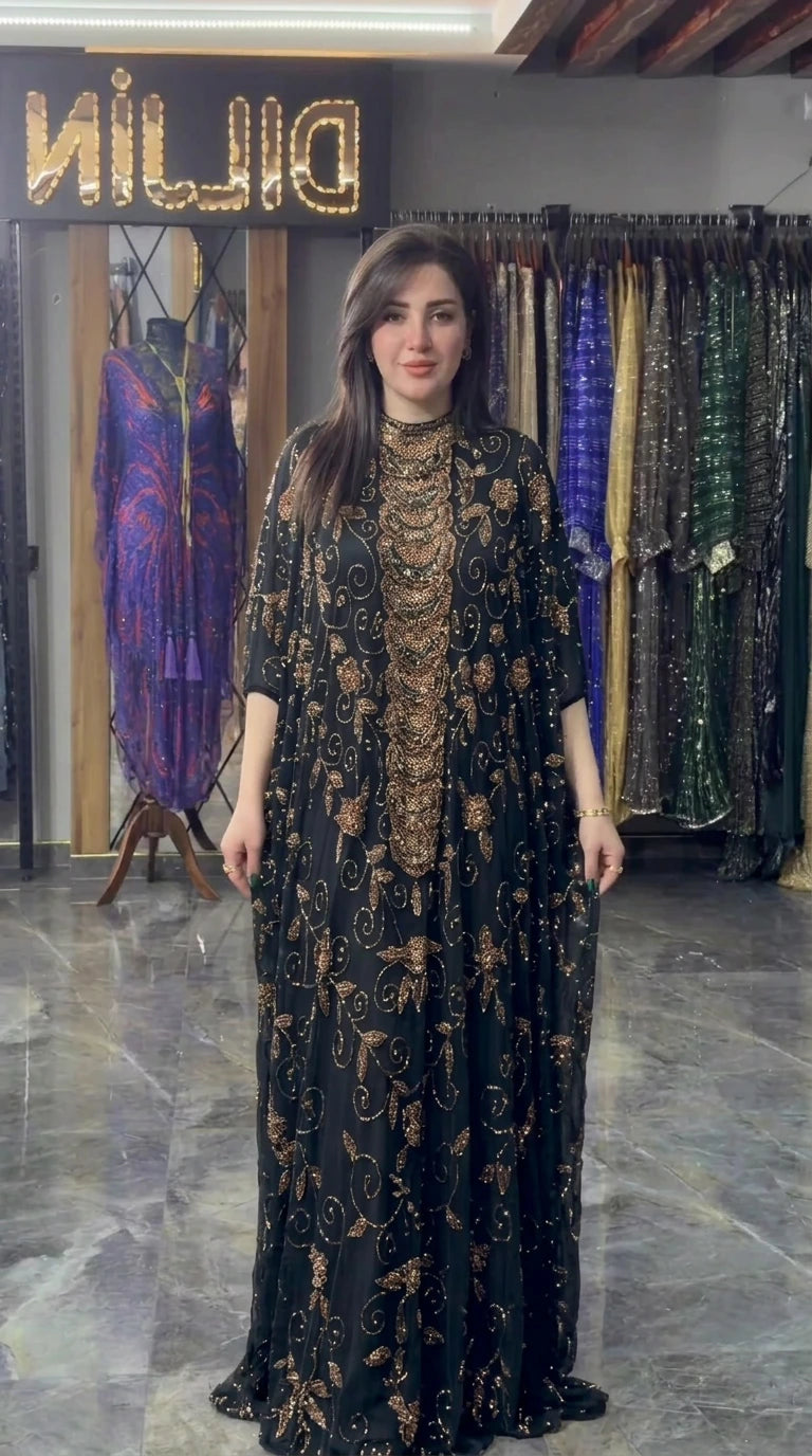 Front view of black hand-beaded cape evening gown with gold accents