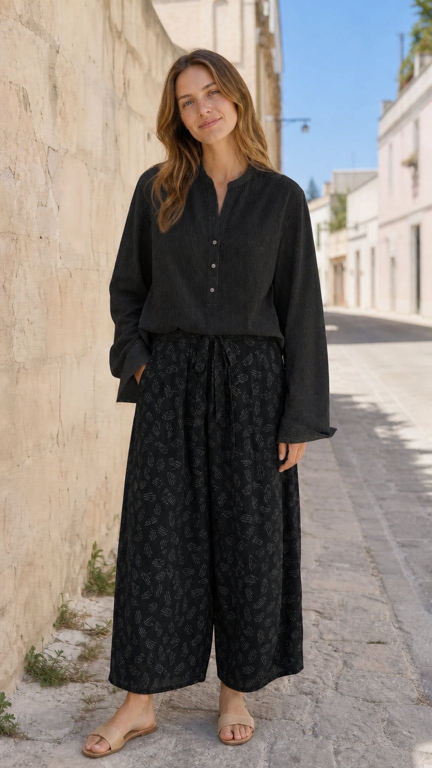 Woman wearing black two-piece blouse and printed pants set
