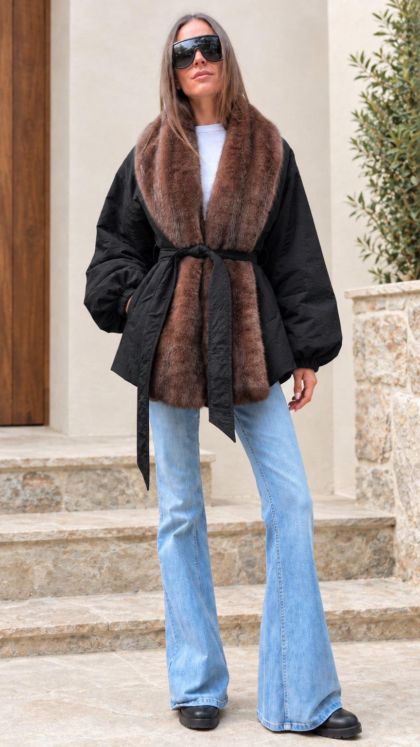 Woman modeling black belted jacket with contrasting brown faux fur trim
