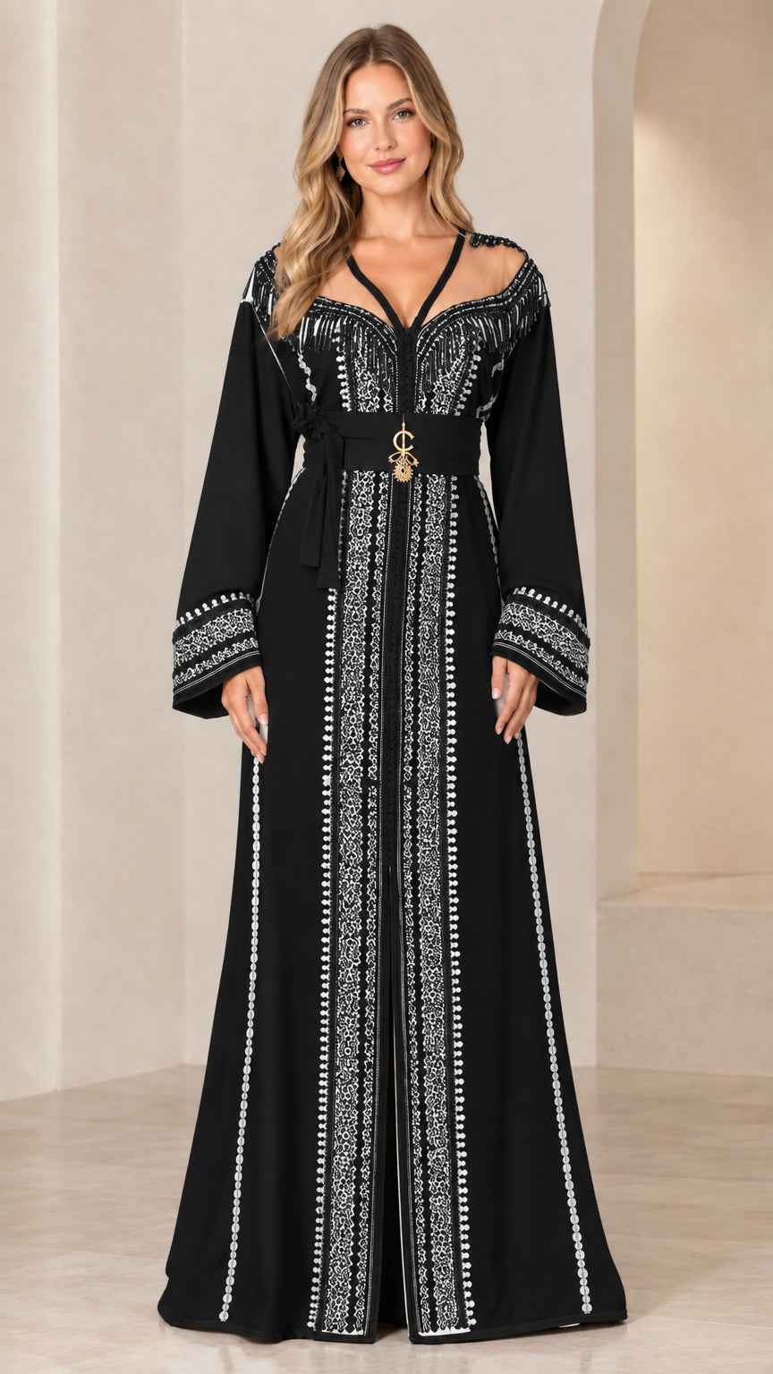 Model wearing black Moroccan caftan gown with intricate white embroidery and belt