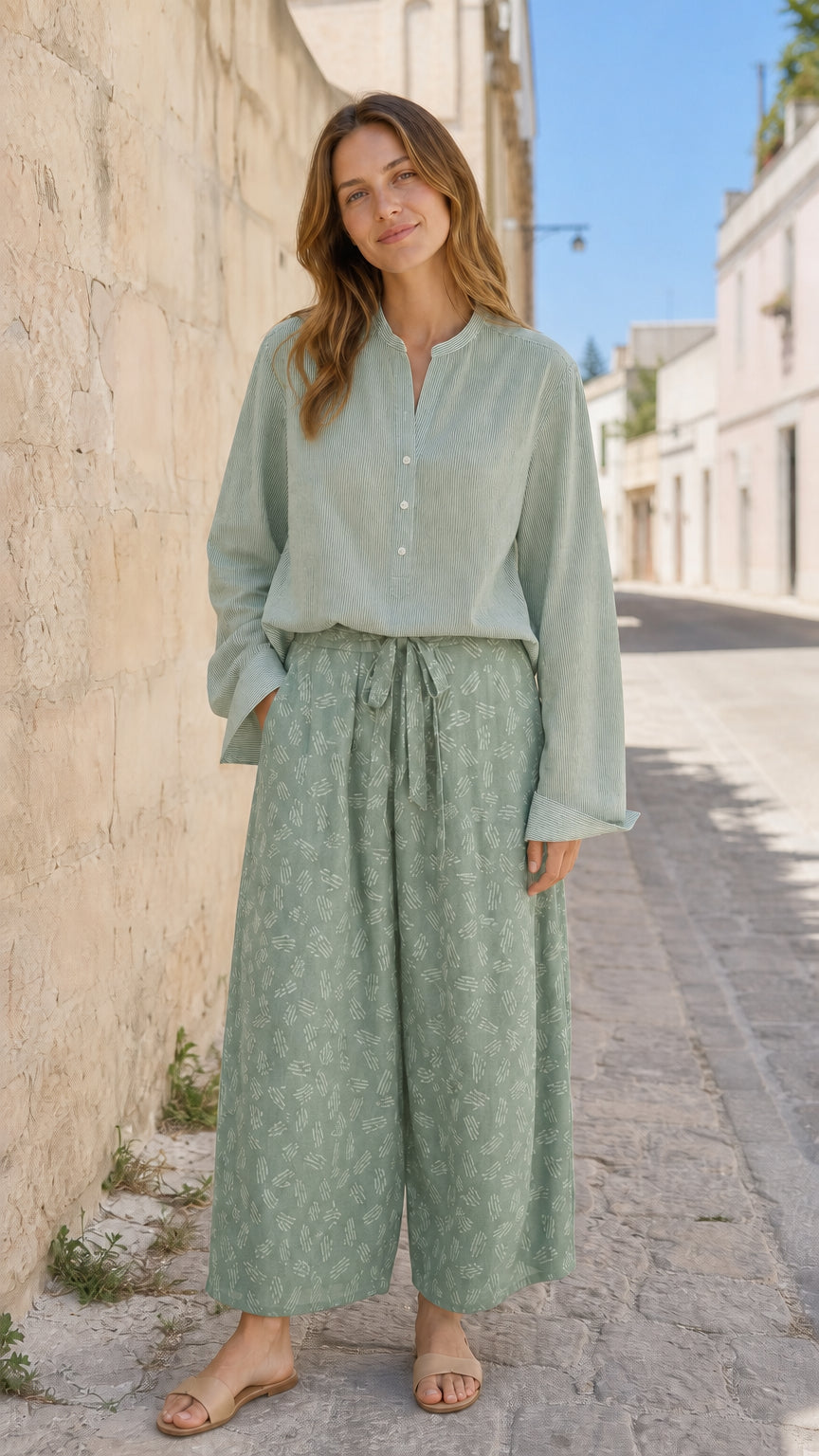 Woman wearing sage green two-piece blouse and printed pants set