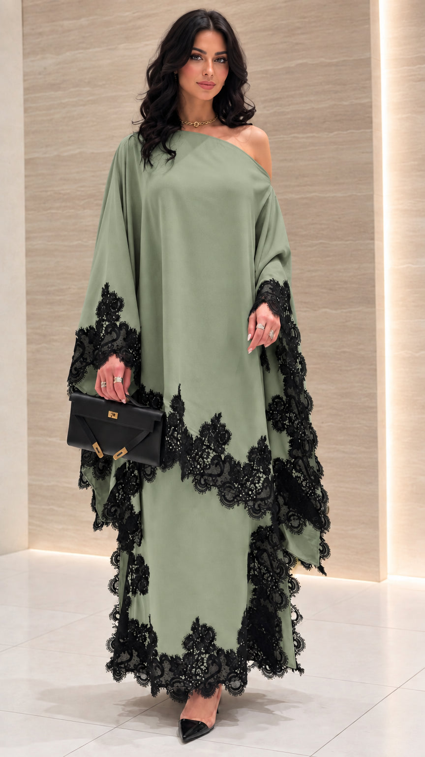 Front view of sage green one-shoulder draped maxi dress with black lace trim