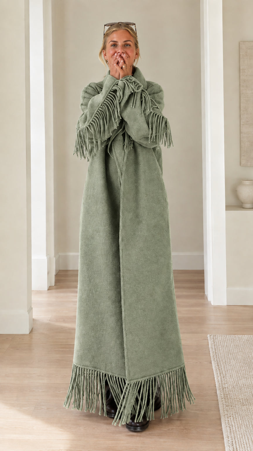 Full-length view of woman wearing sage green fringe trimmed maxi overcoat
