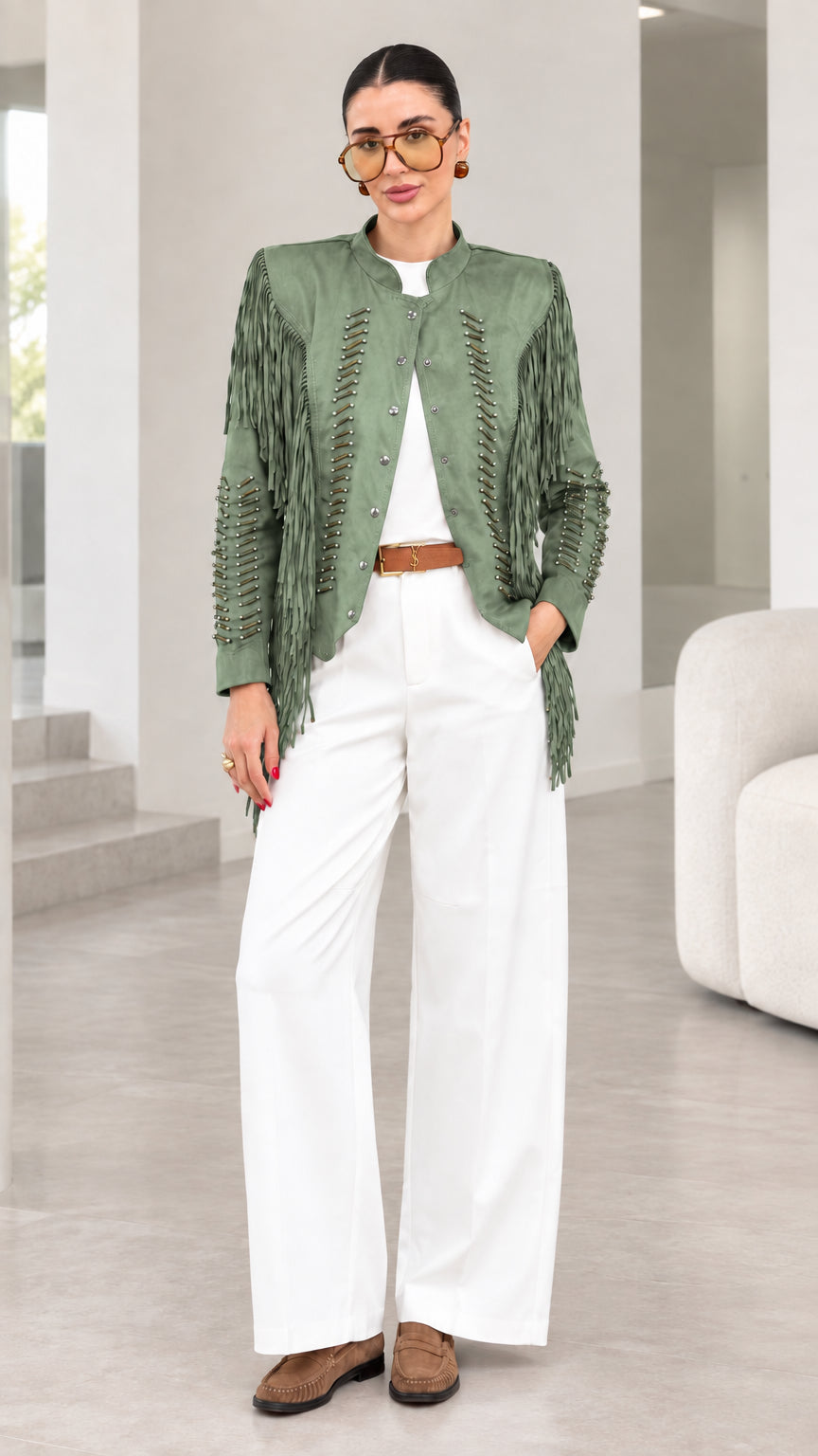 Model wearing sage green faux suede fringe jacket with white pants