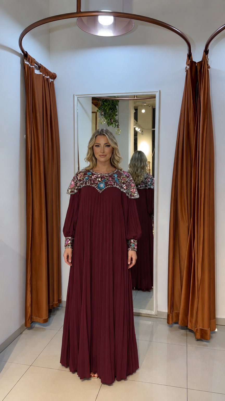 Woman wearing burgundy wine pleated maxi dress with beaded details