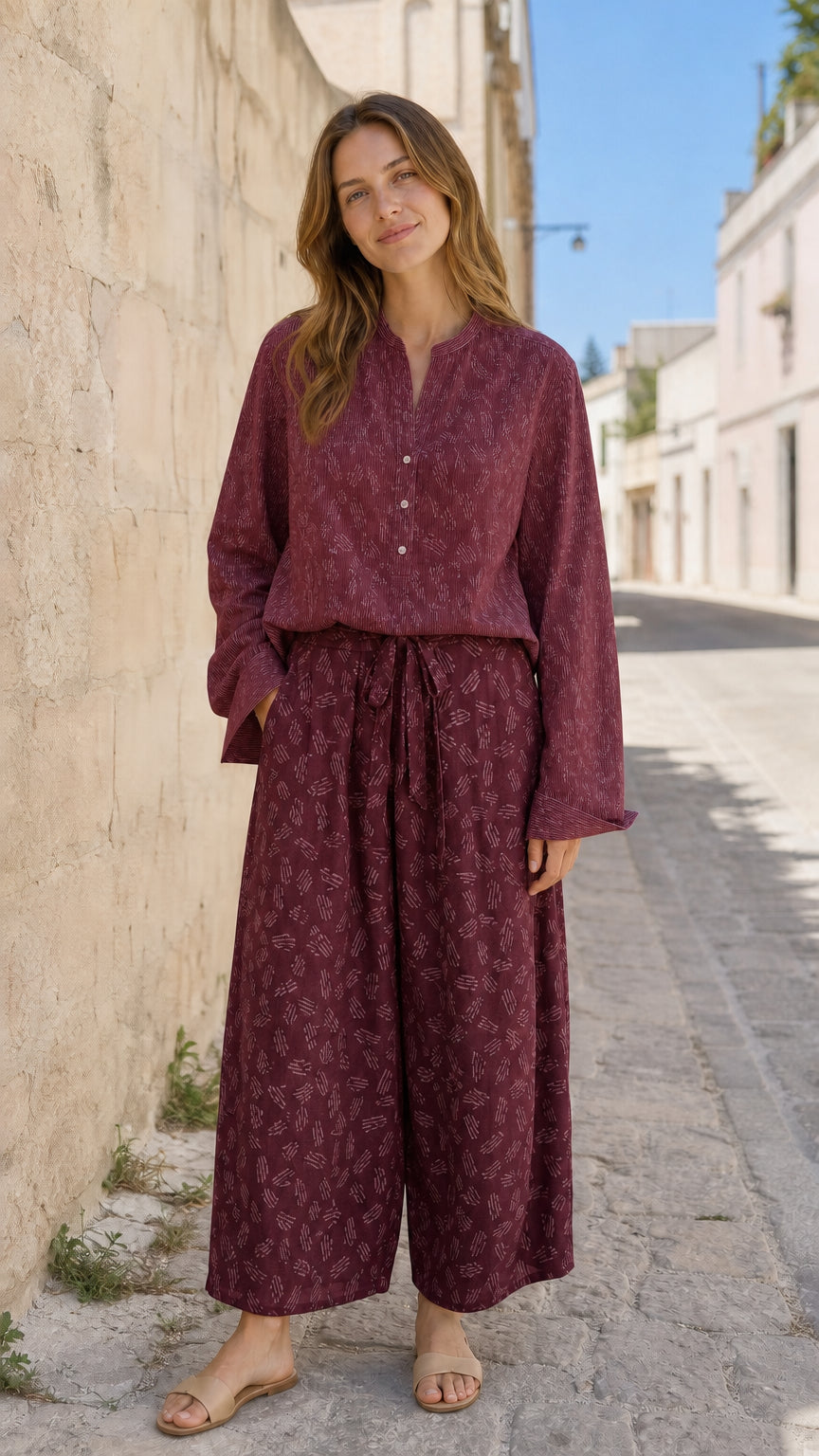 Woman wearing burgundy two-piece blouse and printed pants set